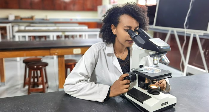 infrastructure and tech-700x375 Young woman looking through microscope